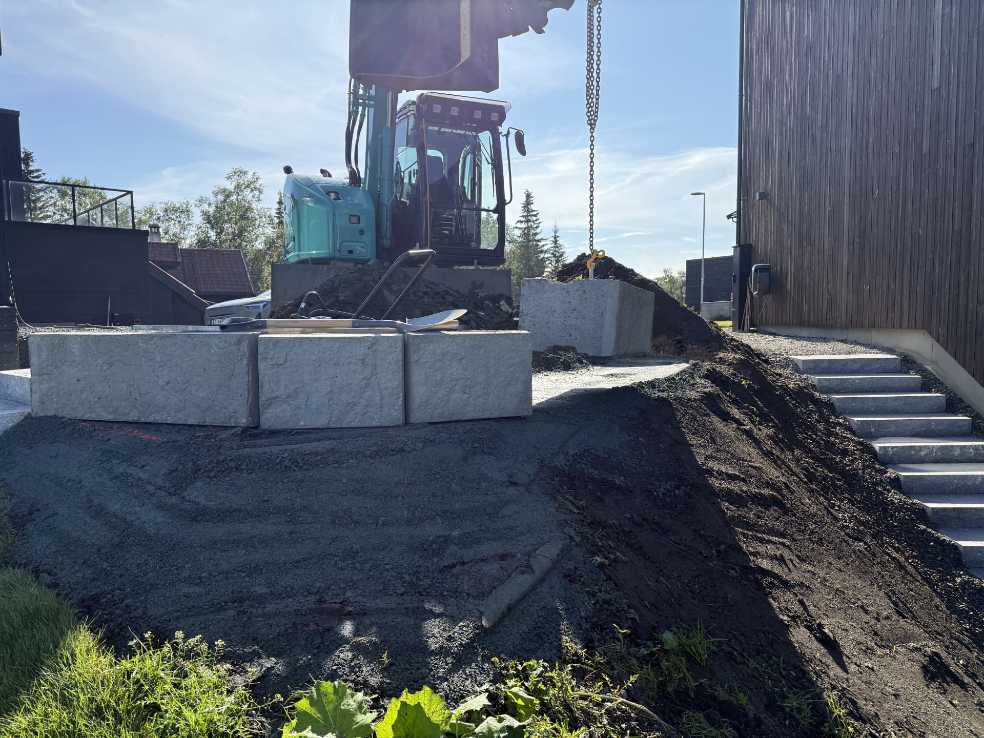 Terrengarbeid med gravemaskin og betongelementer