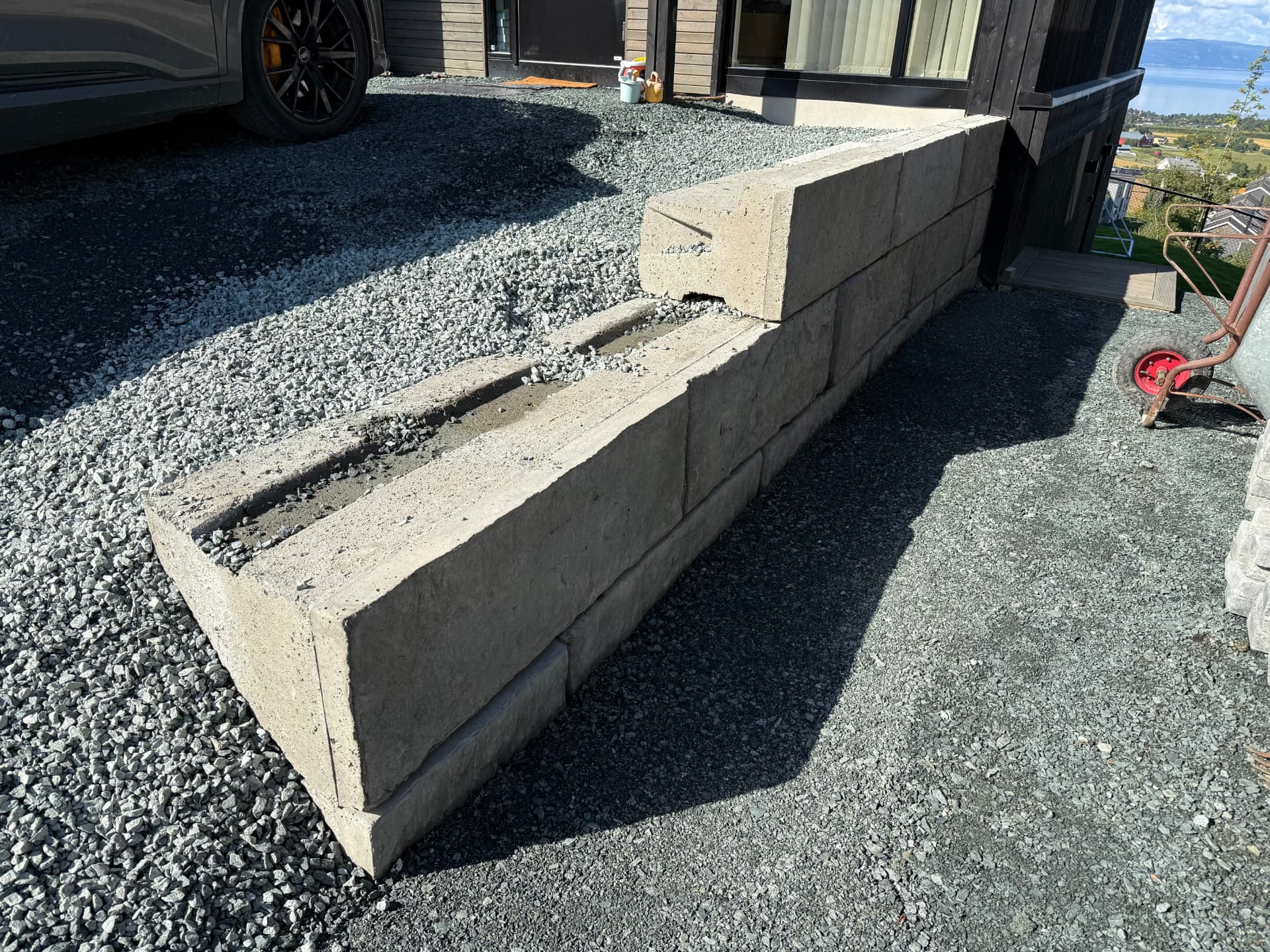 Støttemur av betongblokker i skrånende terreng