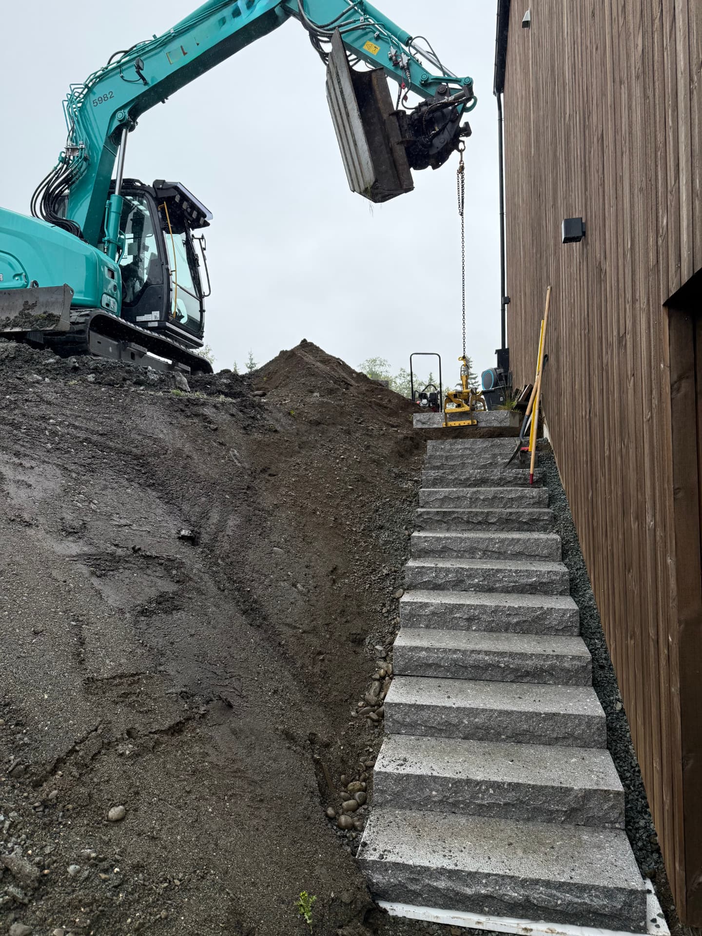 Montering av steintrapp med gravemaskin